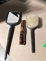 Photo showing mirror, brush, and comb with natural light - front view
