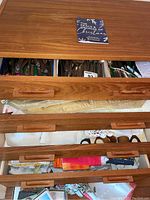 Closed four-drawer wooden sideboard showing drawers slightly opened to reveal linen and flatware contents inside.