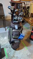 Full view of the golf bag filled with clubs, visible tags and bags, showing overall condition and contents.