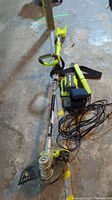 Overview of grass trimmer with charger, battery, laser level case, and work light cord