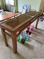 Photo of the wood hall table showing its rectangular shape with wood inlay top and straight legs, set on carpet.