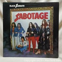Front cover of Black Sabbath Sabotage album showing band members standing framed in an ornate gold frame with the album title in bold red letters.