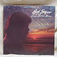 Front cover of Bob Seger & The Silver Bullet Band's vinyl record album 'The Distance'. Shows side profile silhouette of Bob Seger at sunset.