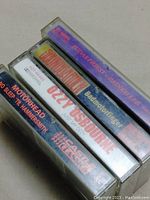 Top view of 5 cassette tapes stacked showing titles Judas Priest Painkiller, Soundgarden Badmotorfinger, Motorhead No Sleep Til Hammersmith, Just Say Ozzy, Castle Classics.