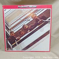 Front cover of The Beatles 1962-1966 Red Album showing the band members looking down from a balcony in brown tones.