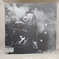Front cover of The Who's Quadrophenia double vinyl album featuring the iconic black and white image of a man standing next to a scooter.