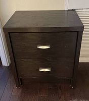 Front view of dark espresso wood bedside table with two drawers closed