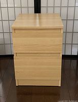 Front view of IKEA Malm 2-drawer chest in light oak veneer finish, drawers closed, showing rectangular shape and smooth top surface.