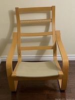 Front view of IKEA Poang armchair frame showing bentwood curved armrests and missing cushion.