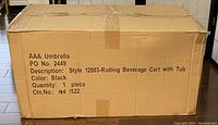 Closed cardboard box labeled with product details: AAA Umbrella, Style 12003 Rolling Beverage Cart with Tub, color black, quantity one piece.