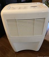 White Whirlpool AccuDry dehumidifier with front air vents and top control panel.