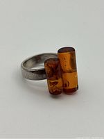 Close-up of the amber stones on sterling silver band showing rectangular amber with natural inclusions and silver band.
