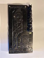 Full view of the carved cribbage board showing Indigenous style artwork and abalone inlays, with the side totem carving.