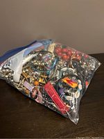 Full freezer bag of assorted costume jewelry items in various colors and styles including bracelets, necklaces, rings, and accessories.