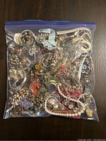 Large freezer bag filled with assorted costume jewelry items shown from top view