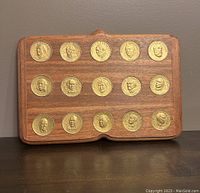 Front view of wooden plaque with 15 brass medallions featuring Canadian Prime Ministers in profile relief.