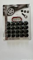 Packaged set of black Mechline wheel bolt covers with illustrations and text on backing card