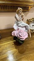 Photo of the Franklin Mint Lady Rose porcelain figurine on a wooden surface.