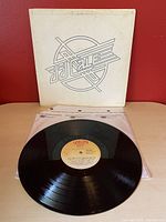 Front cover of the album with J.J. Cale logo on white background and the vinyl record on top of a transparent plastic inner sleeve