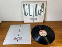 Photo showing front of album cover, inner sleeve, and vinyl record with center label.