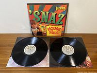 The double vinyl album with both records removed from the cover and displayed on a table. The vinyls have A&M labels, appear clean with minor scuffs.