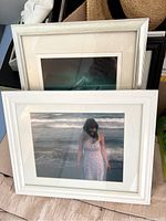 Two stacked frames photographed showing a woman in white dress standing in water with matting.