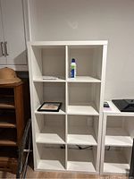 Tall 9-cube IKEA shelving unit empty except for a few small items.
