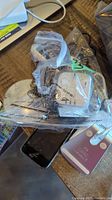 Overview of iPhone 5, wireless chargers, ear buds case, and other accessories on wooden surface.