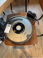 Top view of iRobot Roomba vacuum and charging dock on wooden chair.