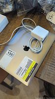Top view of closed MacBook Pro with Apple logo and stickers, plus MagSafe adapter on lid