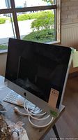 Front view of iMac with screen, stand and cables on table