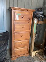Front and side view of five drawer solid pine highboy chest, showing drawers, pine knobs, and wood grain finish with slight wear on pulls.