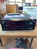 Front view of Onkyo TX-SR700 AV receiver with remote and manual placed on top.