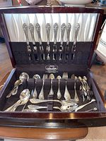 Open wooden canteen with all flatware displayed in lid and base
