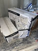 Three cardboard boxes stacked containing Picasso Splitface stone panels with printed labels showing product name and details.