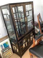 Front and side view of the cabinet showing upper glass display section, lower storage doors, and surrounding details