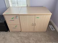 Front angle of light wood finish office desk showing two drawers on left including a locked drawer with attached key, and double-door cabinet on right.