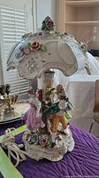 Full view of lamp showing shade, base figurines and floral details