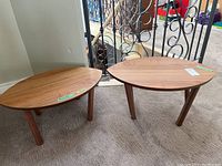 Two Ikea Stockholm coffee tables of different sizes side by side, showing overall shape and wood finish.