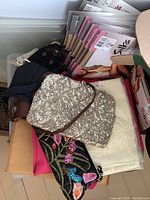 Assorted evening and embroidered bags with multiple packages of Silks pantyhose and shawls or scarves.