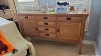 Full front view of oak sideboard with items on top