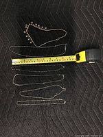 Six necklaces laid out flat next to tape measure showing similar necklace lengths