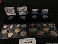 Two RCM 2010 uncirculated coin sets with eight coins each, plus two colorized commemorative coins in individual boxes, one featuring Princess Diana on a Kennedy Half Dollar and the other Barack Obama on a $1 coin.