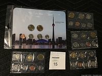 Photo of five Royal Canadian Mint coin sets in blister packs including 2011 CN Tower set and other years.