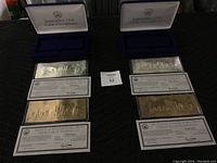 Two sets of September 11th coin certificates with their respective boxes, displaying silver and gold certificates and certificates of authenticity.