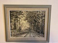 Full view of the framed charcoal drawing showing the forest road and surrounding trees.