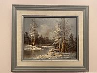 Original winter landscape painting with snowy trees and river, signed Langdon, in silver frame