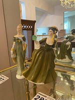 Both Royal Doulton figurines placed together showing their details and complementary style