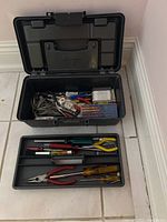 Black plastic toolbox open showing removable tray with hand tools
