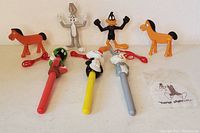 Full view of two vintage bendable Pokey horses and three cartoon character pens including Bugs Bunny, Daffy Duck, and Marvin the Martian.